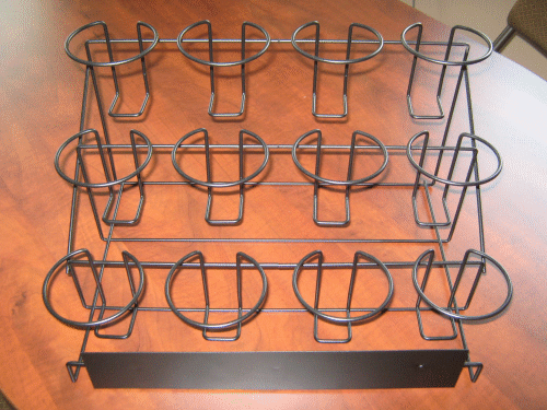 Wire rack with multiple cup holders on a wooden surface, viewed from above.