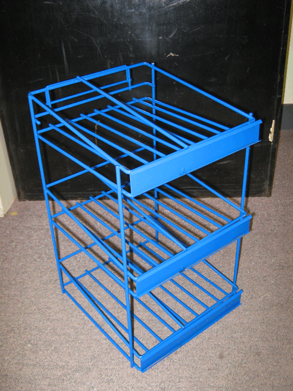 Blue metal folding rack or cart with shelves, angled on beige carpet against a dark background