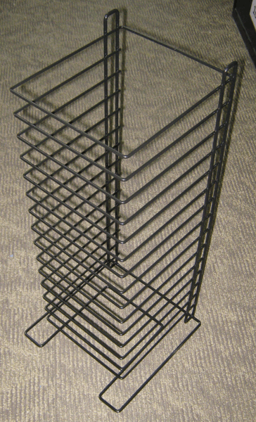 Tall black metal rack with many wire shelves on a beige carpet.