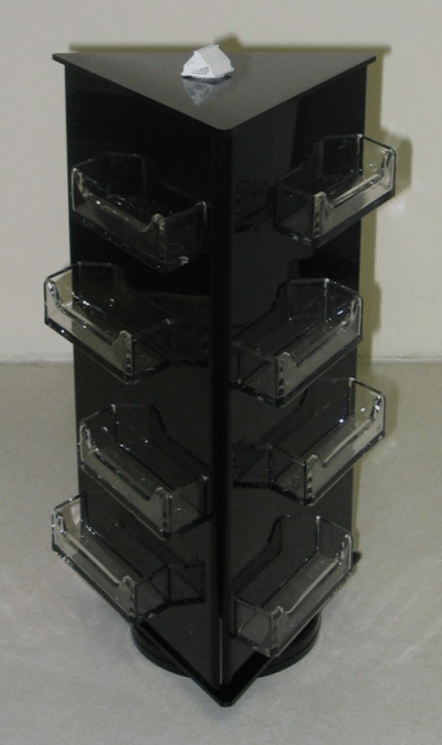 Black rotating display rack with clear plastic drawers on a light floor.