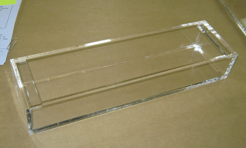 Clear acrylic rectangular tray on a beige surface