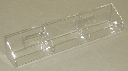 Clear plastic organizer tray with multiple compartments on a beige surface