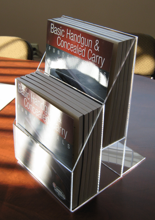 Brochure display stand with pamphlets, including one titled “Basic Handgun & Concealed Carry”