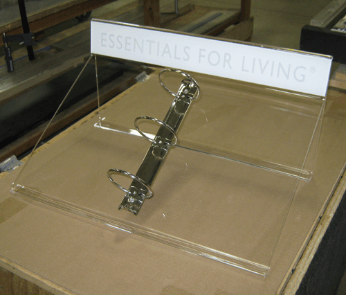 Clear binder on display with a white label reading “ESSENTIALS FOR LIVING.”