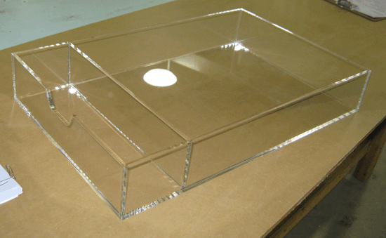 Clear acrylic tabletop organizer with a white circular hole on a wooden surface