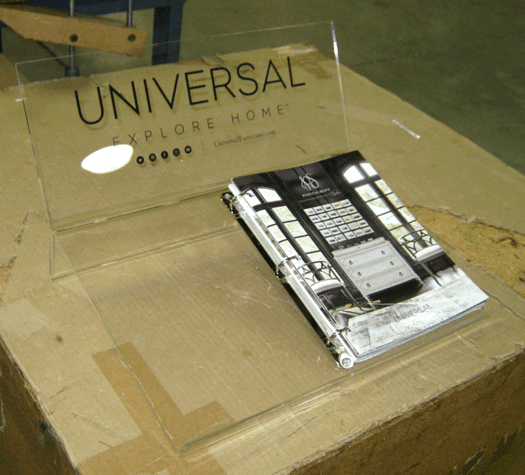 Cardboard box labeled “UNIVERSAL” with a smartphone wrapped in plastic on top