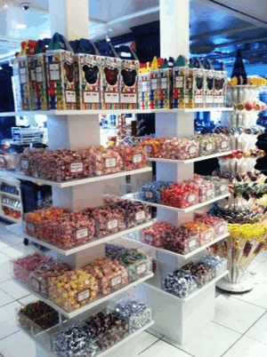 Candy display with shelves of colorful wrapped sweets in a bright store interior