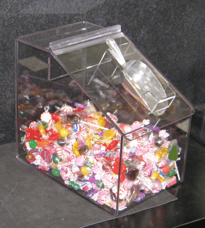 Clear plastic candy bin filled with colorful wrapped candies and a metal scoop on top