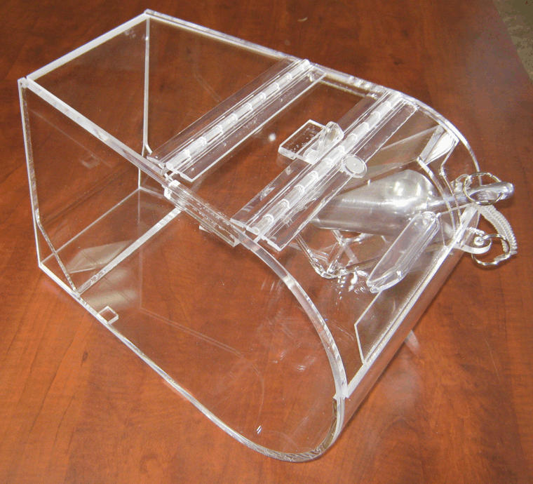 Clear plastic mouse trap on a wooden surface