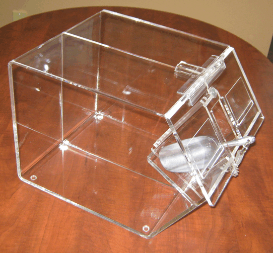 Clear acrylic box with a hinged front door on a wooden table