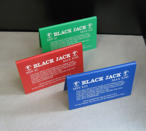 Three black jack packs in red, green, and blue on a gray surface