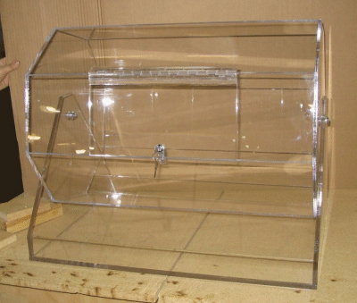 Clear acrylic display case with a slanted front and hinged door on a wooden surface