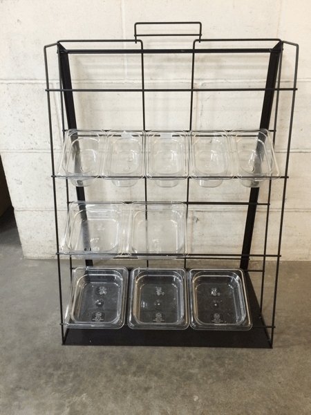 Black wire countertop display rack with clear plastic trays and three small metal bins on the bottom.