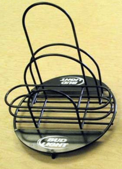 Black metal wire basket with handle and round base, sitting on a beige surface