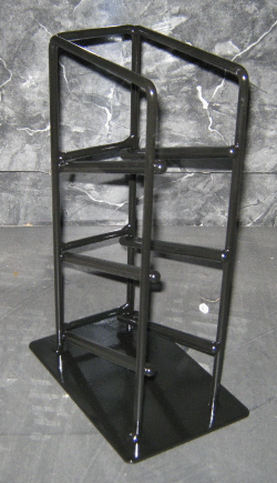Black metal shelving unit with four shelves on a rectangular base against a gray backdrop
