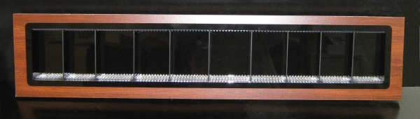 Wood-framed rectangular wall vent with black slats and a silver grille