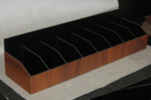 Wooden magazine file organizer with black dividers on a tabletop