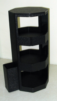 Black multi-tiered shelving unit with a small side cabinet against a light wall.