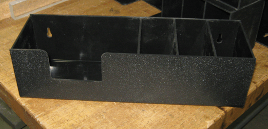 Black plastic storage bin with compartments on a wooden surface