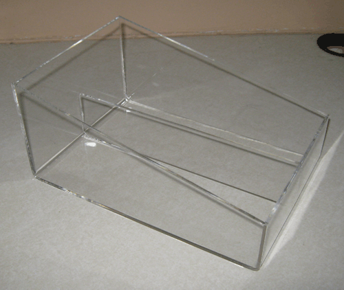 Clear acrylic rectangular storage box with an angled divider on a beige surface