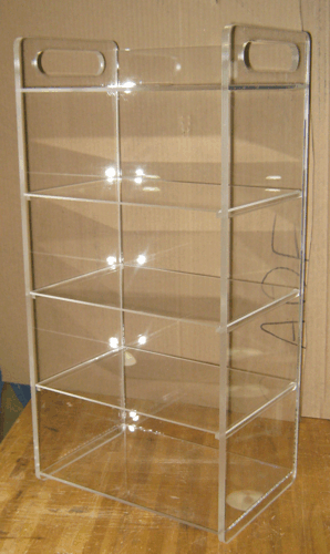 Clear acrylic three-shelf display rack with side handles on a wooden floor