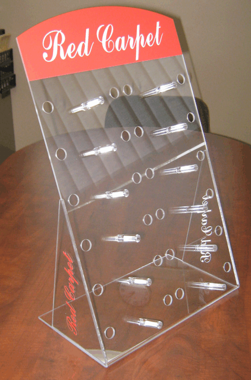 Clear acrylic countertop display rack with red “Red Carpet” header and multiple small shelves