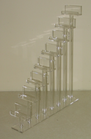 Clear acrylic staircase-like sculpture with stepped rectangular frames on a light background