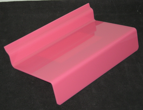 Pink plastic chair armrest cap on a black background