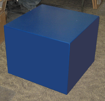Blue cube-shaped object on a carpeted floor in a room