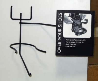 Black metal over-door shoe rack beside a sign reading