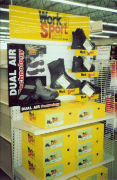 Store display of yellow-and-black WorkSport Dual Air shoes and boxes on a retail floor