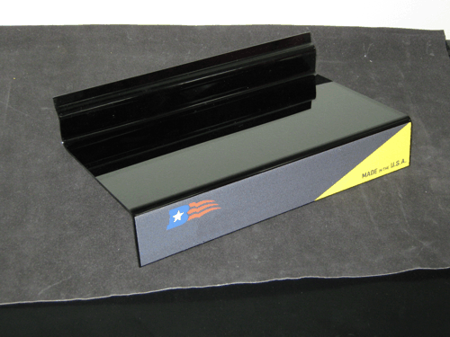 Black display stand with a blue-and-yellow label on a gray surface.