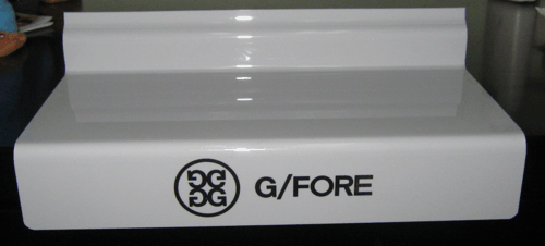 White G/FORE display stand with black logo and text on a gray background
