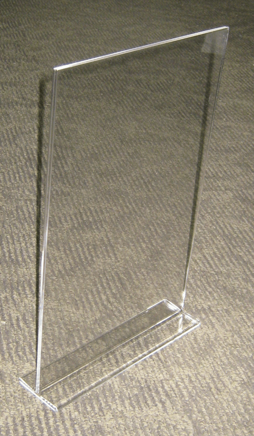 Clear acrylic display stand on a textured surface, shown at an angle.