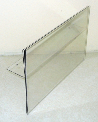 Clear acrylic display sign holder on a white surface, angled side view