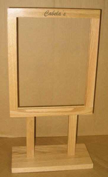 Small wooden tabletop sign or display board with a blank tan inset, on a stand.