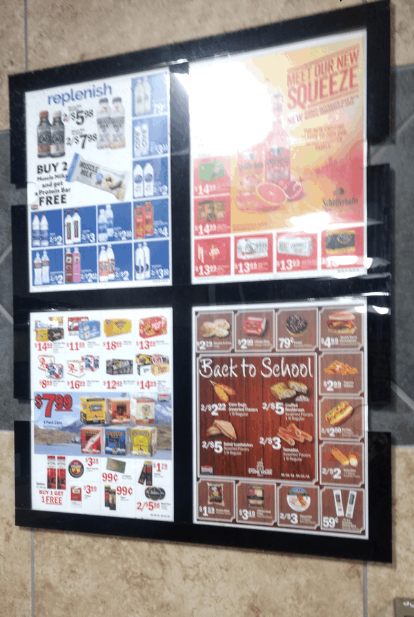 Storefront window with four colorful promotional posters advertising food and drinks