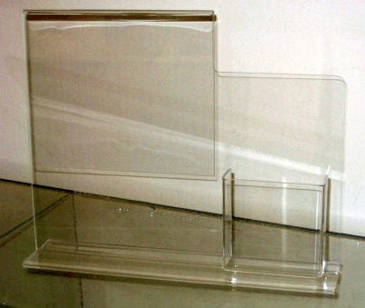 Clear acrylic brochure display stand with three compartments on a plain surface