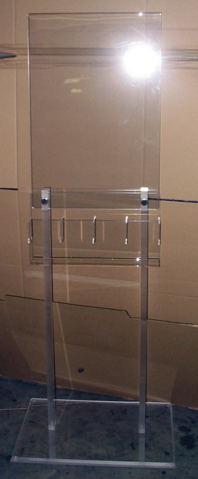 Clear acrylic podium with microphone stands in front of a wooden wall.