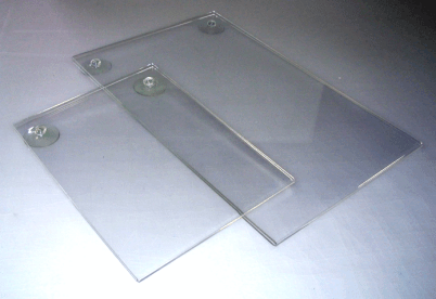 Two transparent plastic document holders with metal screws on a white surface.
