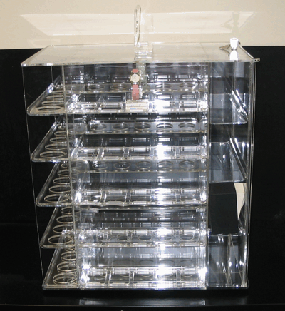 Clear acrylic rotating display rack with multiple shelves, shown front view against a black background
