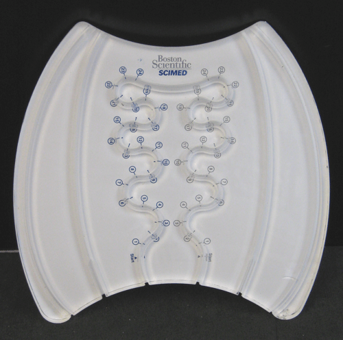 White SCAD breast brace with blue fitting markers and straps on a dark background