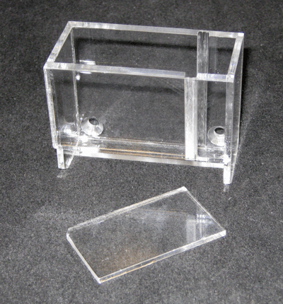 Clear acrylic organizer box with a removable lid on a dark surface