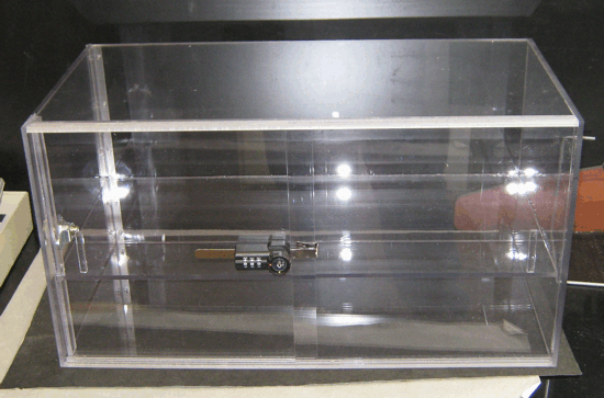Clear acrylic display box with a latch, sitting on a table