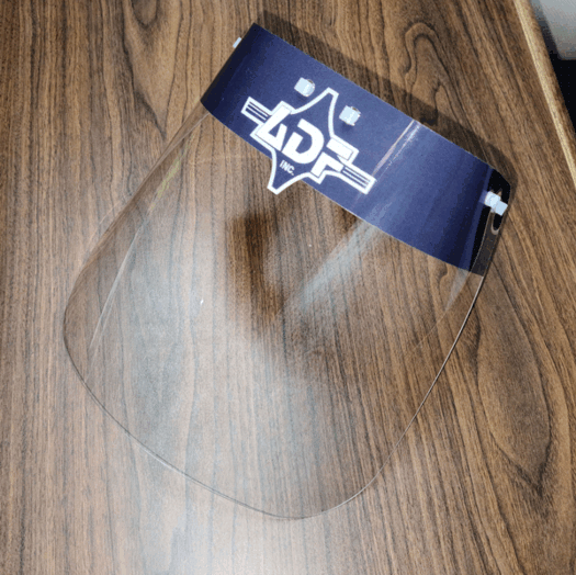 Clear round glass plate with a blue tag on a wood-grain surface.
