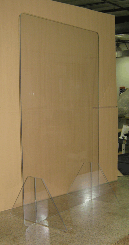 Clear acrylic floor-standing barrier in front of a large tan wall panel indoors