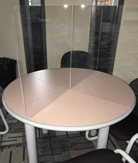 Round table with clear plastic divider in a cafe seating area