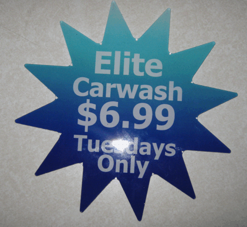 Blue starburst sign reads “Elite Carwash $6.99 Tuesdays Only.”