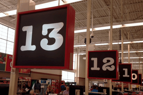Store aisle signs showing numbers 13 and 12 hanging from the ceiling