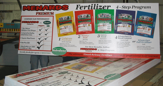 Menards fertilizer display showing a step-by-step lawn care program with product bags and application chart